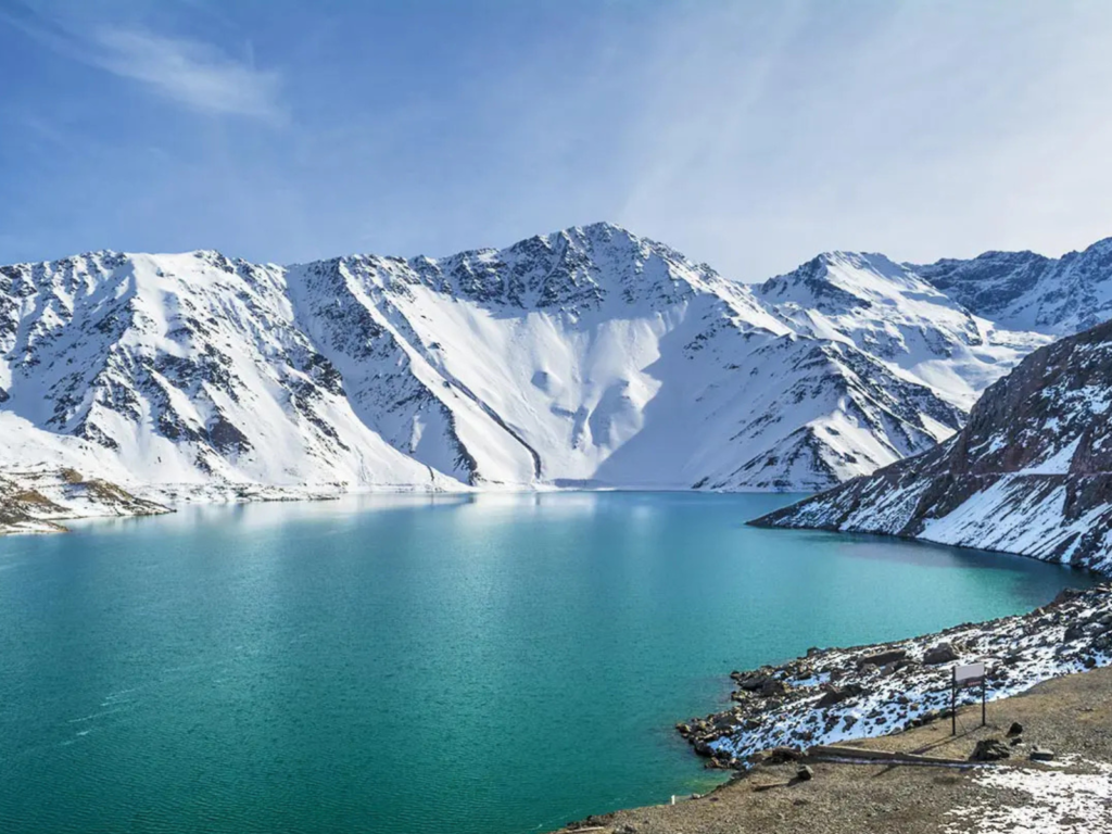 Laguna del Inca em Portillo no Chile com águas azul-turquesa cercadas por montanhas nevadas da Cordilheira dos Andes