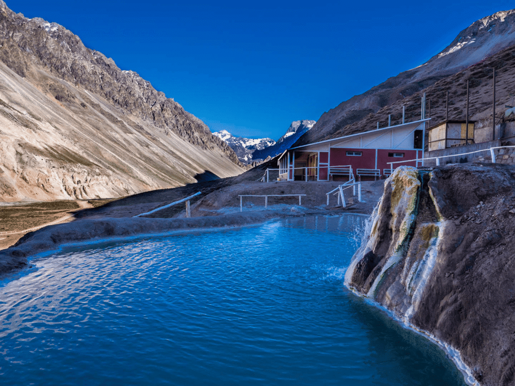 Piscinas termais naturais escalonadas das Termas da Colina em Baños Colina, Cajón del Maipo, com a imponente Cordilheira dos Andes ao fundo, no Chile.