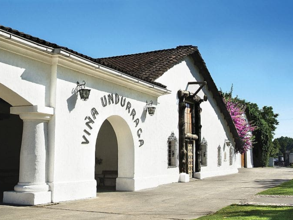 Caminho arborizado e jardins históricos da tradicional vinícola Viña Undurraga, localizada no Vale do Maipo, Chile. (Se a foto for das caves, troque para: Turistas em degustação de vinhos nas caves subterrâneas da Viña Undurraga no Vale do Maipo, Chile